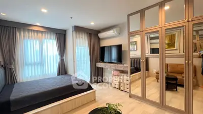 Modern bedroom with stylish decor, large mirrored wardrobe, and natural light from windows.