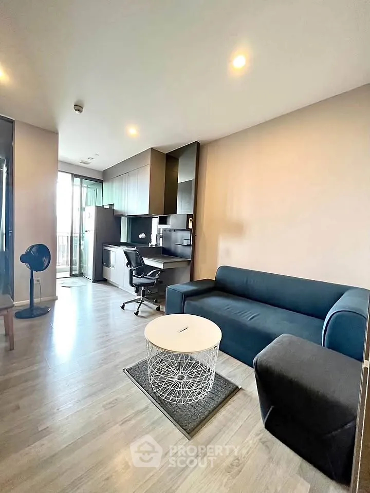 Modern living room with sleek furniture and open kitchen layout in a stylish apartment.
