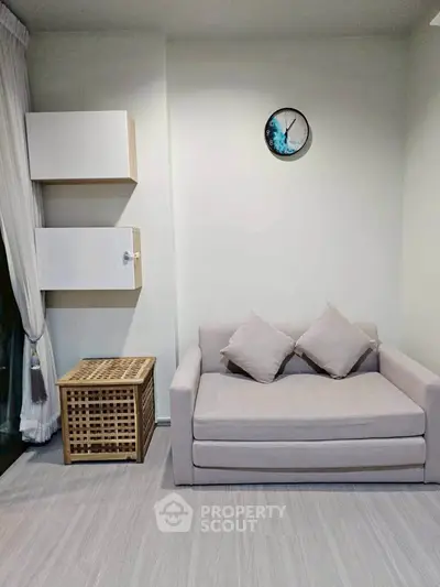 Cozy living room with modern sofa and stylish wall clock, perfect for relaxation.