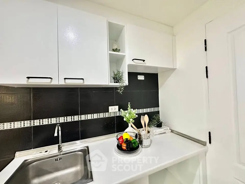 Modern kitchen with sleek white cabinets and black backsplash