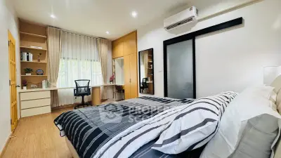 Modern bedroom with study area, featuring stylish decor and ample natural light.