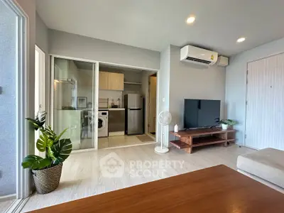 Modern living room with open kitchen, air conditioning, and stylish decor