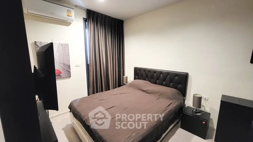 Cozy modern bedroom with plush bed and stylish decor in a contemporary apartment.