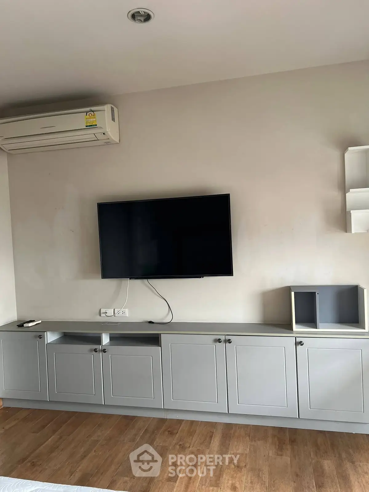 Modern living room with wall-mounted TV and sleek cabinetry