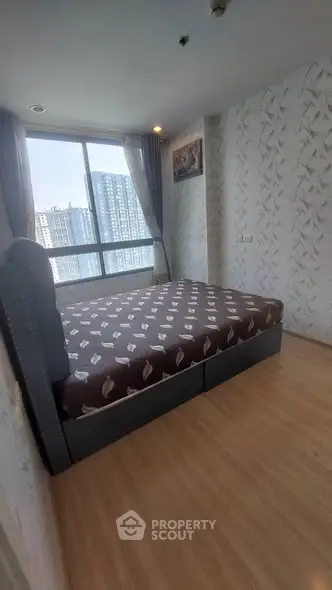 Spacious bedroom with large window offering city view in modern apartment