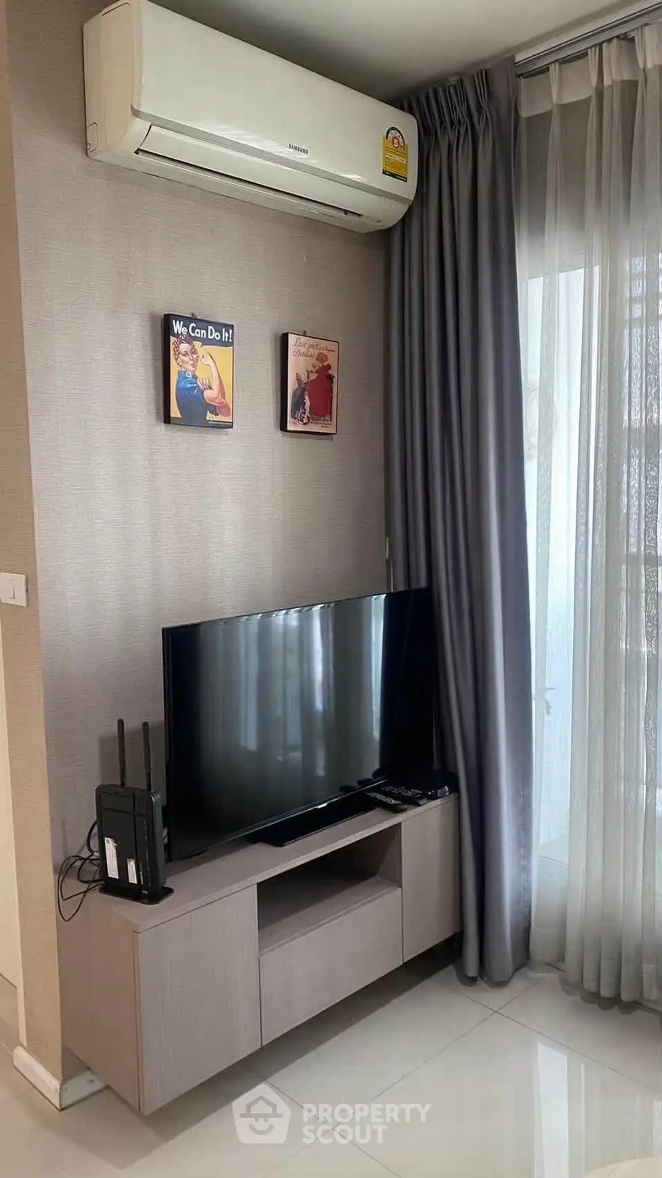 Modern living room with sleek TV setup and air conditioning, perfect for comfortable living.