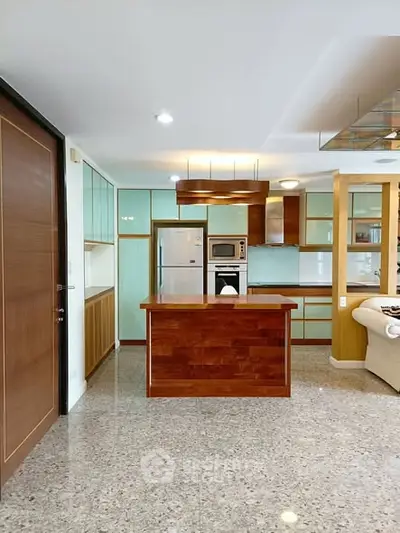 Modern kitchen with sleek design, featuring an island and built-in appliances.