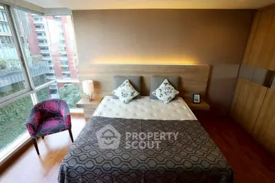 Luxurious bedroom with modern decor and large windows offering a stunning city view.