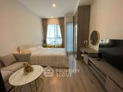 Modern bedroom with cozy decor and large window offering natural light