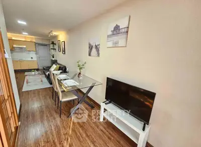 Modern living room with dining area and TV, featuring stylish decor and open kitchen layout.