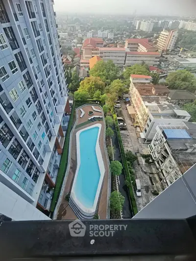 Stunning aerial view of modern high-rise building with luxurious swimming pool and cityscape backdrop.