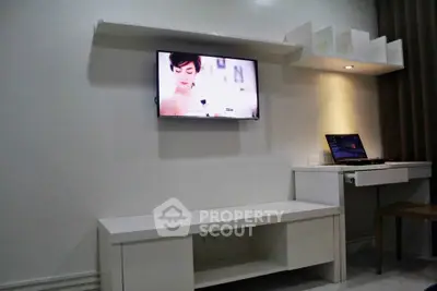 Modern living room with wall-mounted TV and sleek white furniture, perfect for minimalist style enthusiasts.