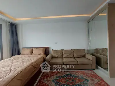 Spacious bedroom with cozy sofa and elegant decor in modern apartment