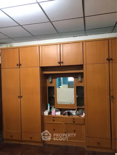 Spacious wooden wardrobe with built-in mirror and ample storage space