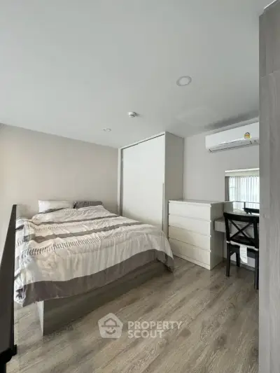 Modern bedroom with sleek design, featuring a cozy bed, stylish dresser, and air conditioning unit.
