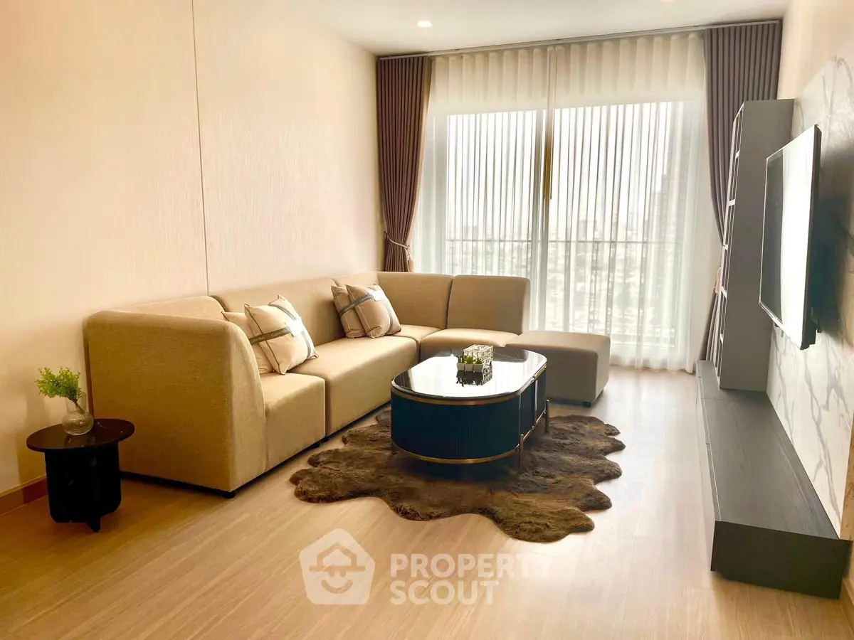 Spacious modern living room with elegant decor and large window view.
