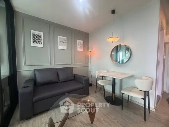 Modern living room with stylish decor, featuring a sleek sofa, elegant dining set, and contemporary lighting.
