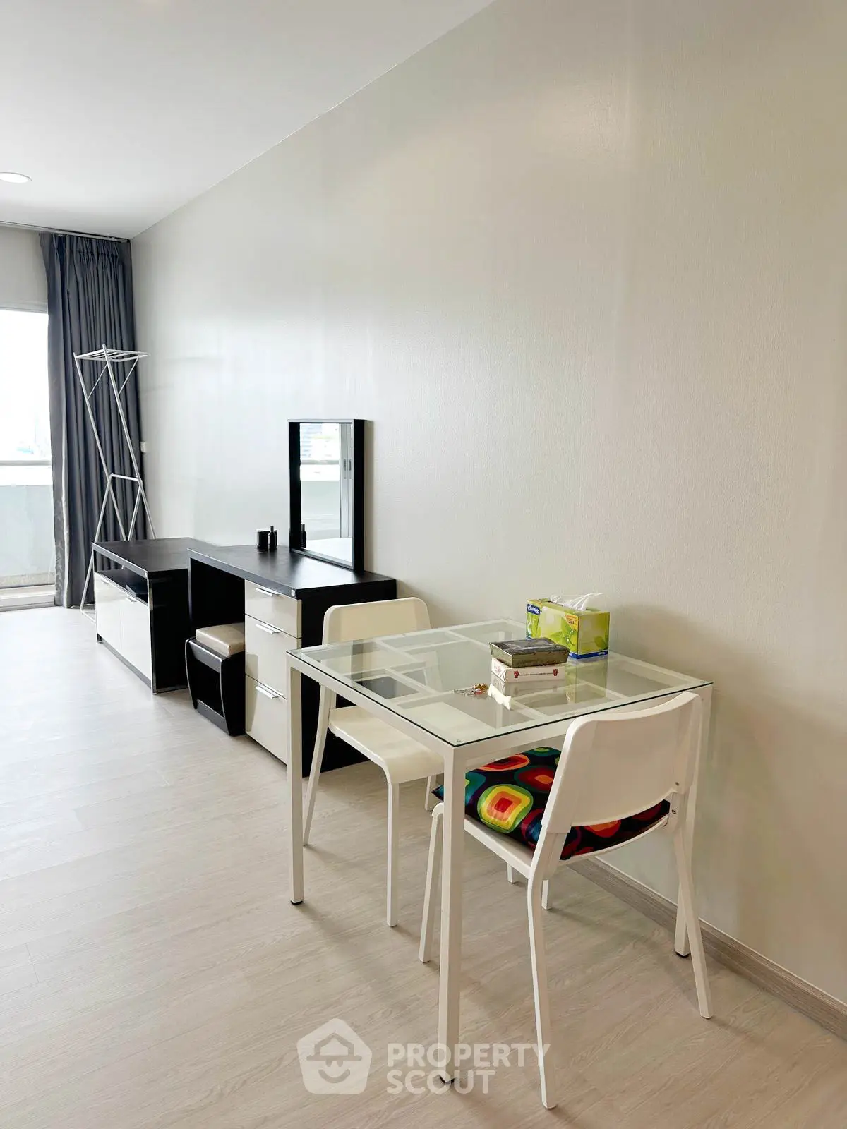 Modern living room with sleek furniture and glass table, bright and spacious ambiance.