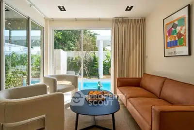Stylish living room with pool view, modern furniture, and natural light.