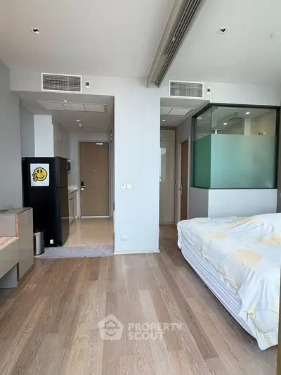 Modern bedroom with wooden flooring and stylish decor in a contemporary apartment.