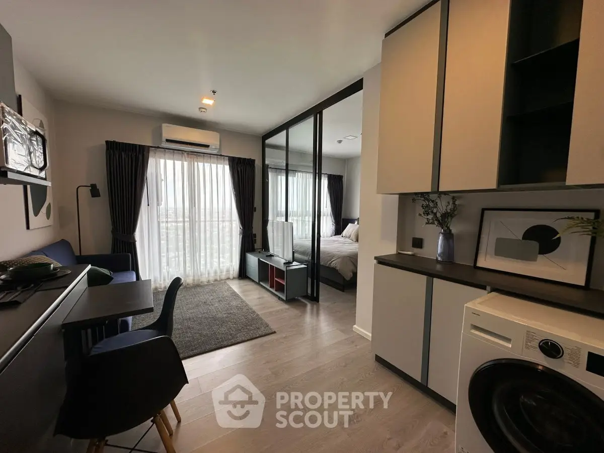Modern apartment interior with open layout, featuring a cozy living area and stylish bedroom separated by glass partition.