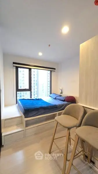 Modern bedroom with large window and cozy bed in urban apartment