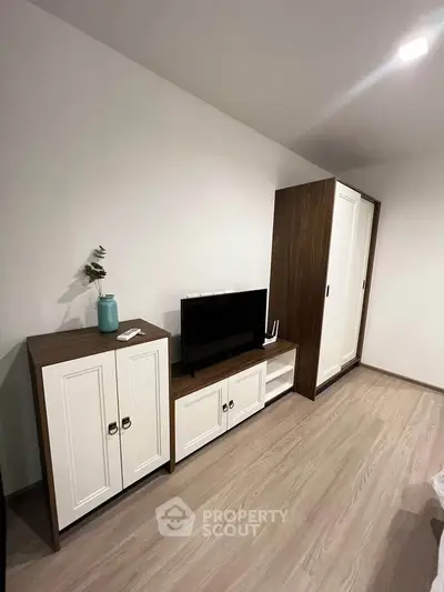 Modern living room with sleek wooden furniture and flat-screen TV, perfect for cozy relaxation.