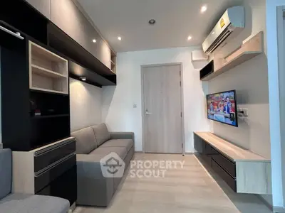 Modern living room with sleek furniture and wall-mounted TV in a stylish apartment.