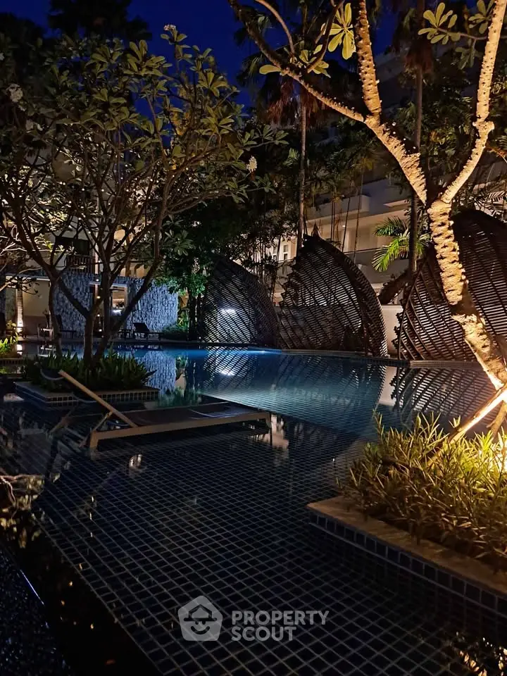 Luxurious night view of a modern pool area with stylish seating and ambient lighting, perfect for relaxation.