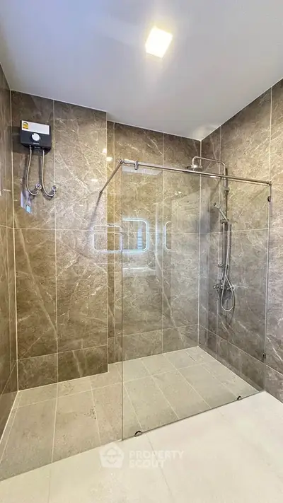 Luxurious modern bathroom with elegant glass shower enclosure and marble tiles