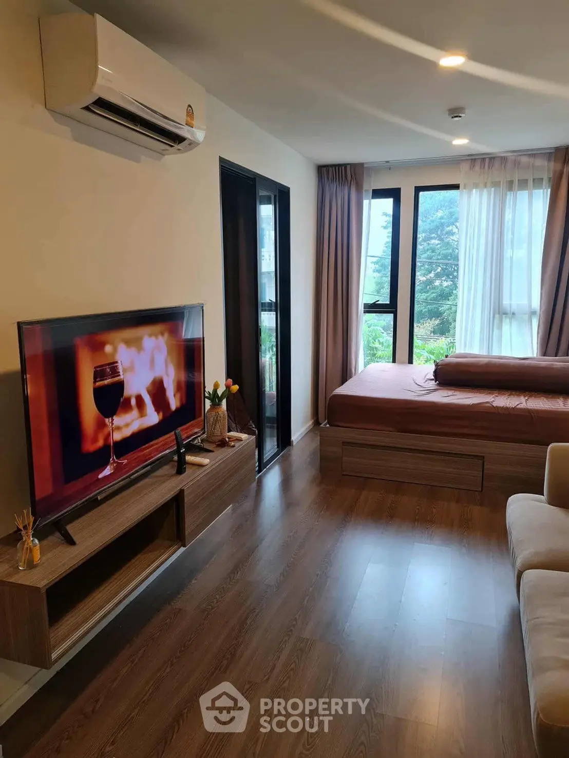 Modern studio apartment with cozy decor and large windows offering natural light and scenic views.