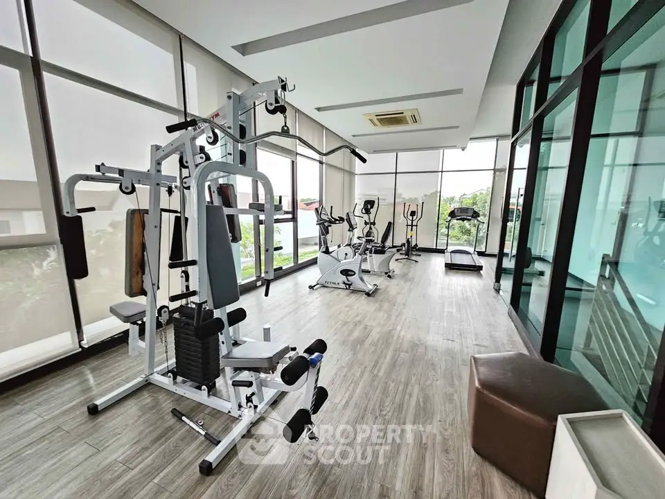 Modern gym with state-of-the-art equipment and large windows offering a scenic view.