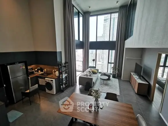 Spacious modern loft with high ceilings, large windows, and stylish open kitchen in urban setting.