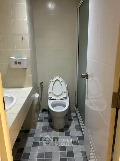 Compact bathroom with modern fixtures and tiled flooring.