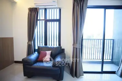 Cozy living room with leather armchair and balcony view