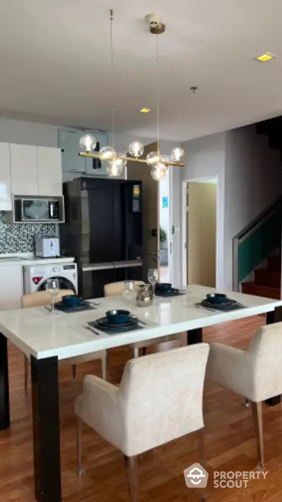 Modern dining area with elegant table setting and stylish lighting in open-plan kitchen