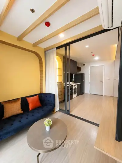 Modern living room with stylish decor and open kitchen layout in a cozy apartment.