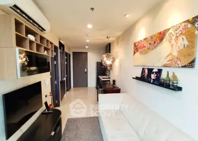 Modern living room with stylish decor and wall art, featuring a cozy sofa and entertainment center.