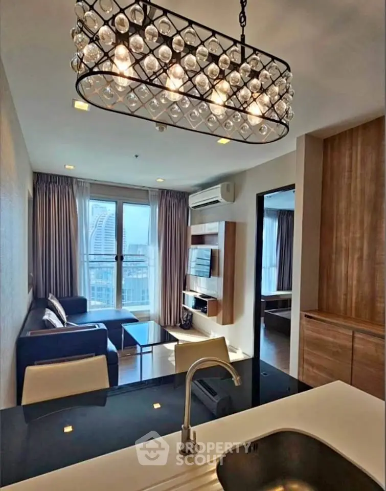 Modern open-layout living room with stylish chandelier and city view, perfect for urban living.