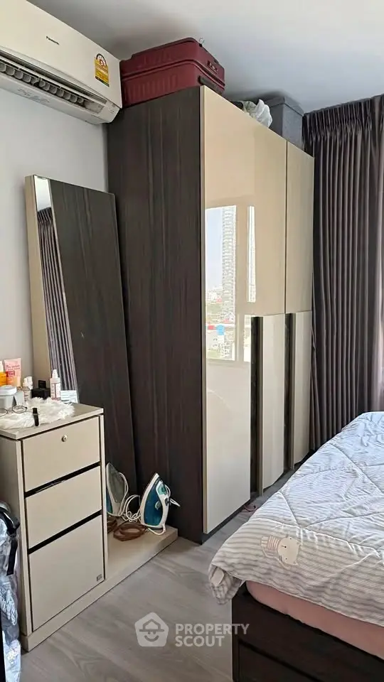 Cozy bedroom with modern wardrobe and air conditioning, perfect for comfortable living.