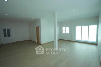 Spacious open-plan living area with natural light and modern flooring