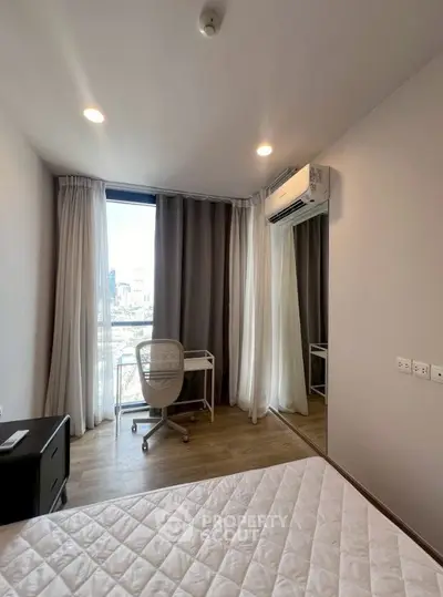 Modern bedroom with large window, desk, and air conditioning in a stylish apartment.
