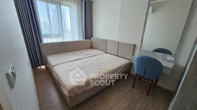 Modern bedroom with large window and stylish furniture in a cozy apartment.