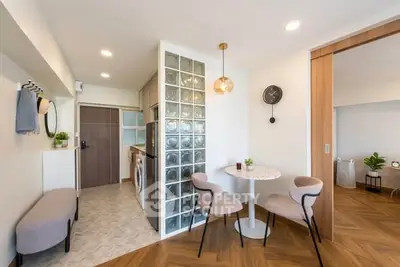 Modern open-plan living area with stylish dining set and glass block partition in a cozy apartment.
