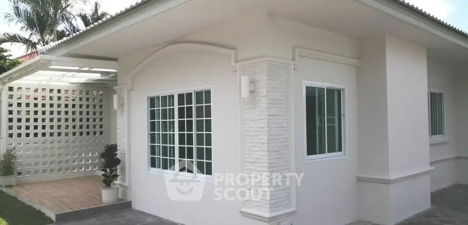 Charming single-story home with modern exterior and lush greenery.