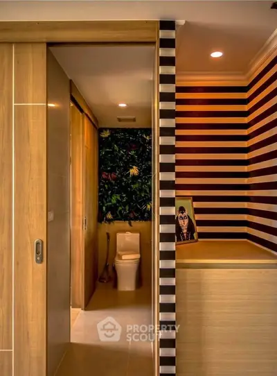 Stylish modern bathroom with unique striped walls and wooden accents