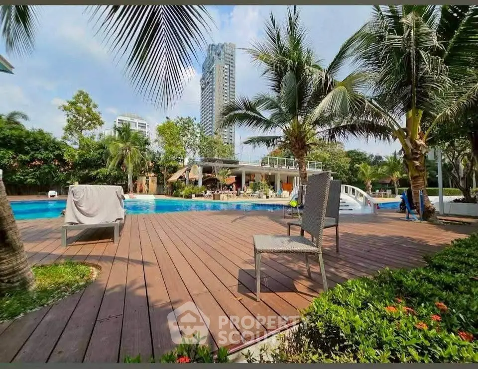 Luxurious poolside area with modern lounge chairs and lush greenery, perfect for relaxation.