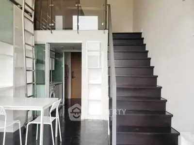 Modern duplex apartment with sleek staircase and compact kitchen