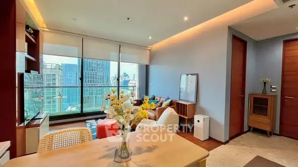 Modern living room with city view, stylish decor, and natural light in a high-rise apartment.