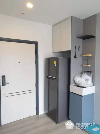 Modern apartment entrance with sleek refrigerator and storage solutions